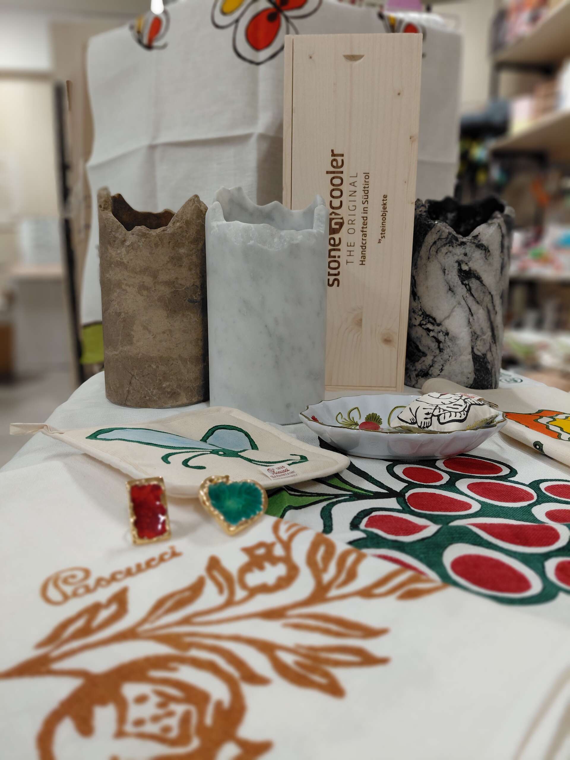 Ambientazione con tele tipiche romagnoli Pascucci, ceramica di faenza, stone cooler alto adige